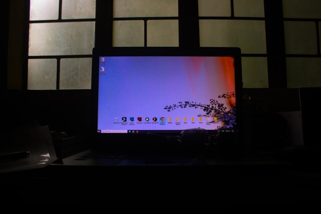 Multiple computer monitors displaying code in a dark office